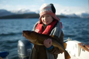 Familienurlaub Norwegen im Winter – Kind mit Dorsch
